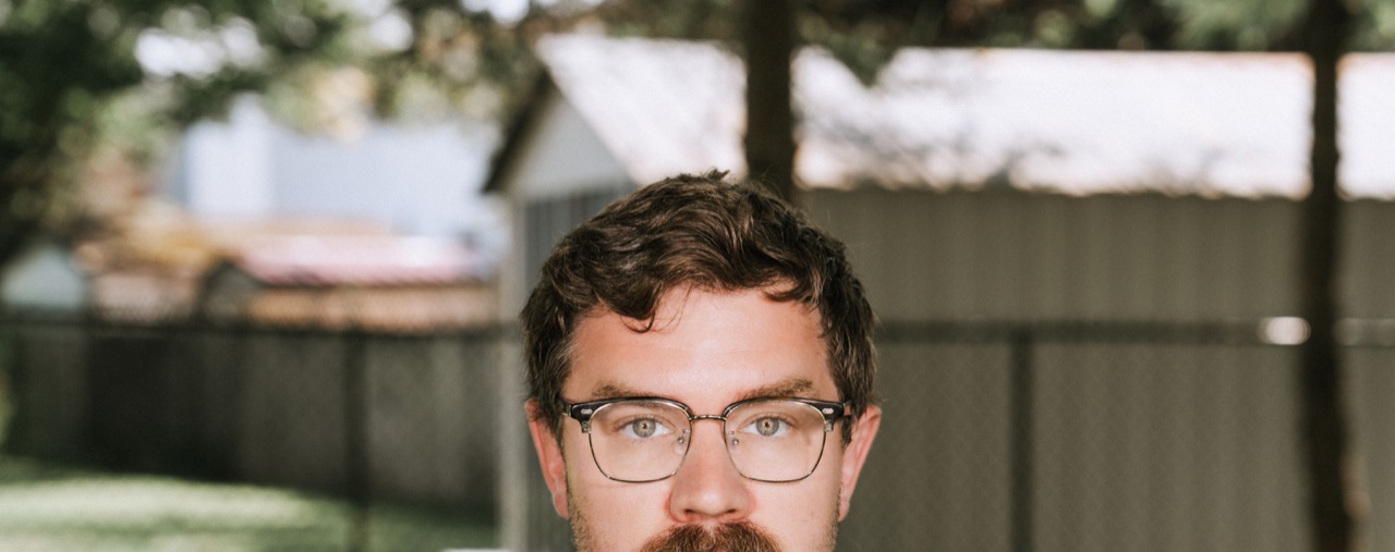 Outdoor portrait of Richard Bacsa wearing glasses.